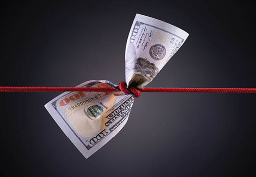 A 100 dollar bill tied up with a red rope.